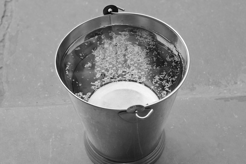 Industry and Violation of Human Right to Water - Greasy layer formed on the top of a bucket filled with water from a tanker in Bichhadi village, Udaipur district, Rajasthan. The tanker supply is organized by Hindustan Zinc Limited, which has caused severe pollution of its drinking water sources through its industrial operations